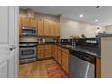 Modern kitchen with wood cabinets, granite countertops, and stainless steel appliances at 317 W Morgan Street # 405, Raleigh, NC 27601