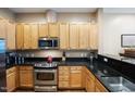 Well-maintained kitchen featuring stainless steel appliances, ample wood cabinetry, and dark countertops for a modern feel at 317 W Morgan Street # 405, Raleigh, NC 27601