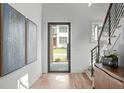 Bright foyer with hardwood floors, modern art, and a view to the front yard at 324 Waldo St, Cary, NC 27511