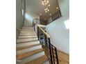 Bright open staircase featuring modern railings, hardwood steps, and a stylish light fixture at 324 Waldo St, Cary, NC 27511