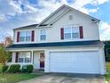 Exterior of a two-story home featuring white siding, shutters, and a spacious two-car garage at 4809 Kaycee Ct, Raleigh, NC 27616