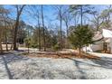 A long gravel driveway and yard with trees and light post leading to the home at 5709 Russell Rd, Durham, NC 27712