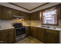 Galley kitchen with wood cabinets, stainless steel appliances, and double sink at 610 Denim Dr, Erwin, NC 28339