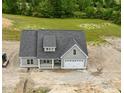 Aerial view of a gray home with a dark roof surrounded by green trees and a construction zone at 6294 River Rd, Fuquay Varina, NC 27526