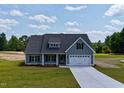 Beautiful one-story home with an attached two car garage and manicured lawn and landscape at 6294 River Rd, Fuquay Varina, NC 27526