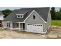 Side view of a new gray home with white trim and a large garage door at 6294 River Rd, Fuquay Varina, NC 27526
