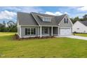 Attractive home with a well-kept lawn, attached garage, and charming curb appeal in a peaceful setting at 6294 River Rd, Fuquay Varina, NC 27526