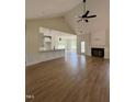 Bright and airy living room featuring a fireplace, ceiling fan, and open access to the kitchen at 6294 River Rd, Fuquay Varina, NC 27526