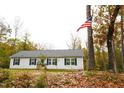 Inviting single-story home with a well-maintained lawn, surrounded by trees, and a patriotic American flag at 979 Natchez Trce, Fuquay Varina, NC 27526