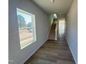 Bright entryway with wood-look flooring, stairs, and a view to the outside through a large window at 103 Central Townes Way # 297, Raleigh, NC 27603
