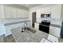 Well-lit kitchen featuring white cabinetry, stainless steel appliances, and granite countertops at 103 Central Townes Way # 297, Raleigh, NC 27603