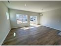 Open living room featuring wood-look floors, natural light, and sliding glass door to the backyard at 103 Central Townes Way # 297, Raleigh, NC 27603