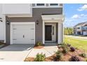 Charming townhome with a single car garage, black front door and professionally landscaped yard at 104 Central Townes Way # 296, Raleigh, NC 27603