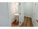 Well-lit powder room featuring a pedestal sink and wood flooring at 111 Central Townes Way # 299, Raleigh, NC 27603