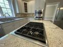 Gourmet kitchen with stainless steel appliances and a large island with a built-in cooktop at 112 Gingergate Dr, Cary, NC 27519