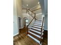 Beautiful hardwood staircase with white risers and banister, offering an open and inviting ambiance at 112 Gingergate Dr, Cary, NC 27519
