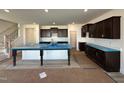 New kitchen features a large island, dark cabinets, stainless appliances, and an adjacent pantry at 1125 Channel Drop Lp, Zebulon, NC 27597