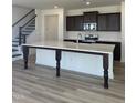 Bright kitchen with a large island, stainless appliances, dark cabinets, and a staircase nearby at 1125 Channel Drop Lp, Zebulon, NC 27597