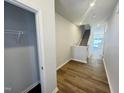 Inviting hallway features hardwood floors, staircase, closet and leads into the open-concept living area at 115 Central Townes Way # 300, Raleigh, NC 27603