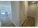 The home's hallway leads to open-concept living, dining, and kitchen areas featuring vinyl flooring at 115 Central Townes Way # 300, Raleigh, NC 27603