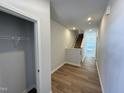 Bright hallway featuring hardwood floors, neutral walls, staircase, and closet with shelving at 119 Central Townes Way # 301, Raleigh, NC 27603