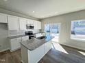 Modern kitchen with white cabinets, granite countertops, stainless steel appliances, and island at 119 Central Townes Way # 301, Raleigh, NC 27603