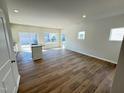 Open-concept living room with hardwood floors, recessed lighting, and sliding glass doors to the backyard at 119 Central Townes Way # 301, Raleigh, NC 27603