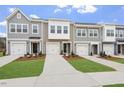 A row of townhomes, each with unique facade details and individual garages and landscaped lawns at 128 Fideaux Blvd # 255, Raleigh, NC 27603