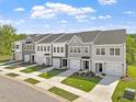 Wide shot showcasing the exteriors of newly constructed townhomes, each with driveways and lawns at 136 Fideaux Blvd # 253, Raleigh, NC 27603