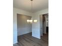 A dining room features a chandelier and detailed wall paneling with hardwood floors at 142 Vega Loop, Sanford, NC 27330