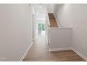 Entryway showcasing hardwood floors leading to a modern kitchen, and stairs with carpet at 144 Fideaux Blvd # 251, Raleigh, NC 27603
