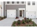 Townhome exterior featuring a front door, mulched landscaping, and two-car garage at 152 Fideaux Blvd # 249, Raleigh, NC 27603