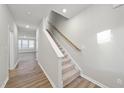 Modern staircase with wood railing and carpeted steps at 21 Nettle Ln # 252, Clayton, NC 27520