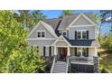 Charming two-story home featuring stone accents, a red front door, and a cozy front porch at 3308 Eden Grove Rd, Fuquay Varina, NC 27526