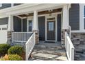 Covered front porch with white railings and stone flooring at 6217 Adcock Rd, Holly Springs, NC 27540