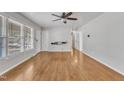 Bright living room featuring hardwood floors, a ceiling fan, and large windows at 704 Sunnybrook Rd, Raleigh, NC 27610