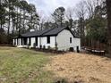 Side view of white brick ranch house, deck, wooded lot at 72 Beverly Dr, Durham, NC 27707