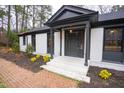 A beautifully designed front porch with black trim and fresh landscaping at 72 Beverly Dr, Durham, NC 27707