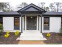 Inviting front porch with white brick steps and a stylish black front door at 72 Beverly Dr, Durham, NC 27707