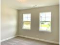 Neutral bedroom showcasing natural light through two windows, plush carpeting, and fresh paint at 82 N Stagecoach Dr, Wendell, NC 27591
