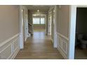 View of a well-lit hallway with decorative trim, wood floors, and an open floor plan at 82 N Stagecoach Dr, Wendell, NC 27591