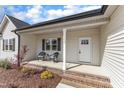 Inviting front porch with stylish chairs, brick trim, and white columns at 9342 Turkey Way, Middlesex, NC 27557