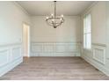 Elegant dining room with decorative trim, modern chandelier, and light hardwood floors at 116 Bearwallow Forest Way, Wendell, NC 27591