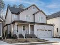 Charming two-story home with a two-car garage, gray siding, and a welcoming front porch at 116 Bearwallow Forest Way, Wendell, NC 27591
