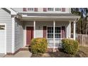 A closer look at the home's front porch, featuring brick detailing, white columns, and shrubbery at 1305 Turks Head Ct, Zebulon, NC 27597