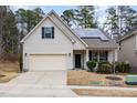 House exterior showcasing a beige facade, solar panels, and a two-car garage at 131 Kinnakeet Dr, Durham, NC 27704