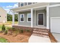 Inviting front porch with brick base, white columns, and a dark-colored front door at 139 Grove Township Way, Angier, NC 27501