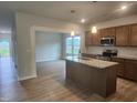 Open kitchen featuring granite countertops, stainless steel appliances, and a center island at 139 Grove Township Way, Angier, NC 27501