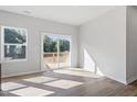 Open living space with natural light, sliding glass doors to a deck, and wood-look floors at 157 Grove Township Way, Angier, NC 27501