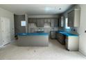 Open concept kitchen with gray cabinets, island, and space for dining at 173 Grove Township Way, Angier, NC 27501